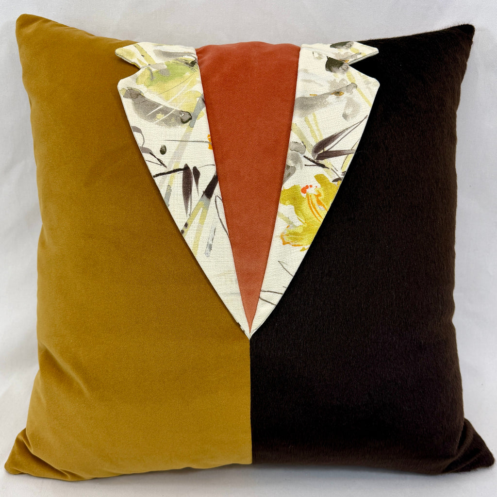 A square decorative throw pillow with a split velvet design: one half is mustard yellow, the other half is very dark brown, and the center features a vertical rust-orange panel flanked by white patterned fabric with brown  and yellow floral details.