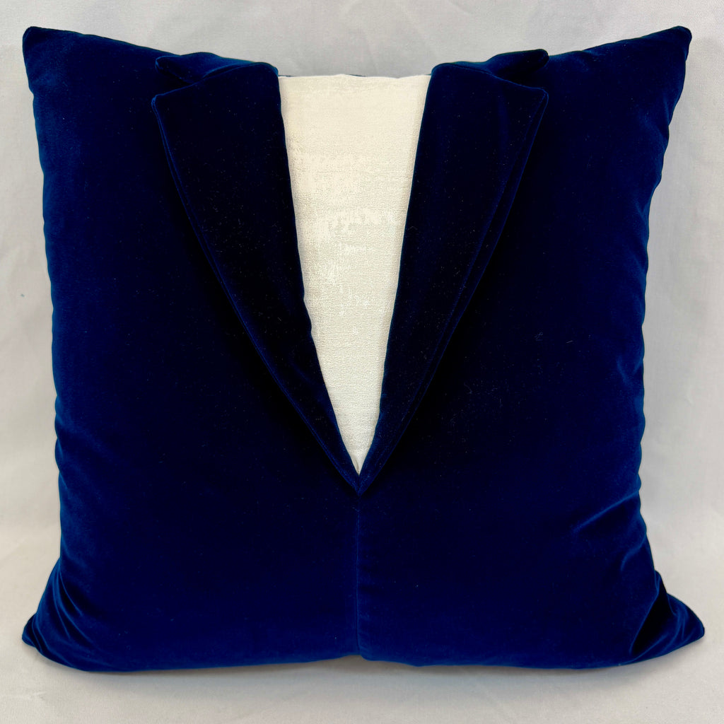 A square throw pillow designed to look like a velvet tuxedo jacket, featuring a deep royal blue body with a white textured V-shaped center panel.