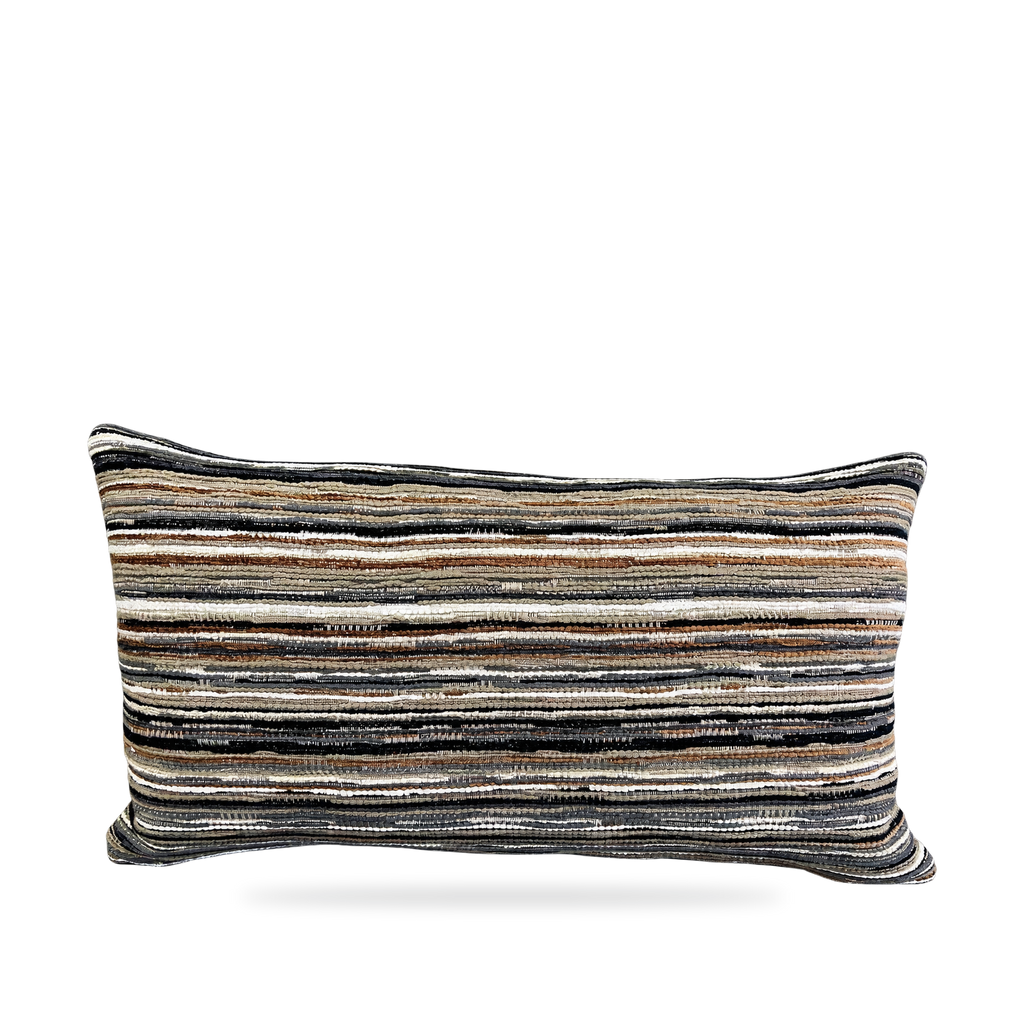 A rectangular throw pillow with a textured horizontal striped pattern in black, beige, brown, and white, shown against a plain white background.